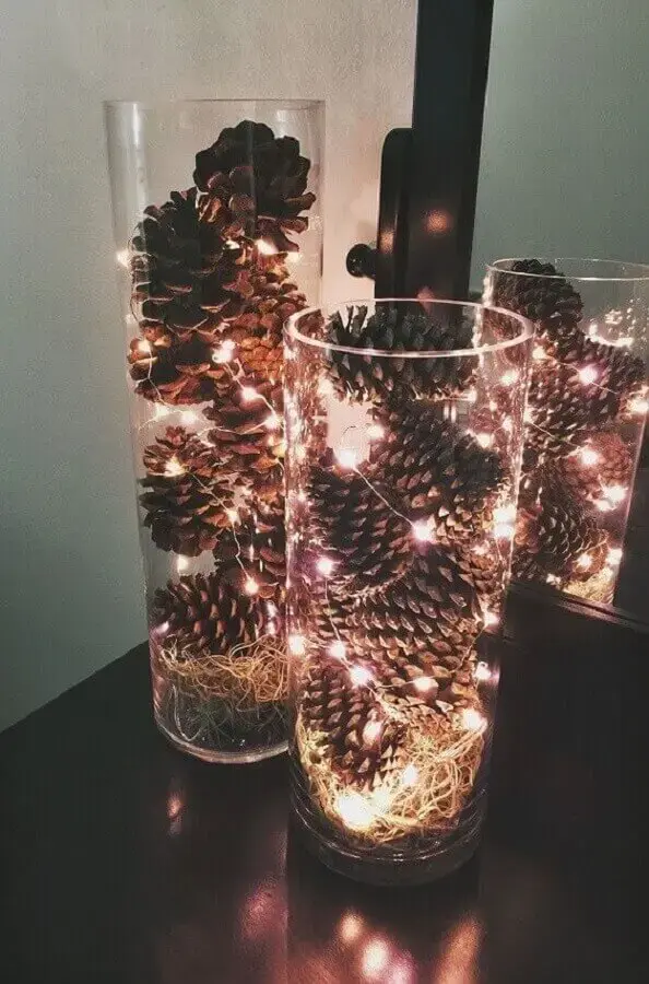 ideias de decoração de Natal simples com pinhas e pisca pisca dentro de vasos de vidro Foto Pinterest