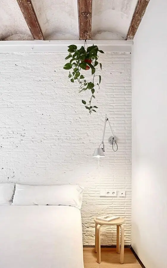 quarto branco decorado com parede de tijolinho branca e luminária de cabeceira articulada Foto HomeWorldDesign