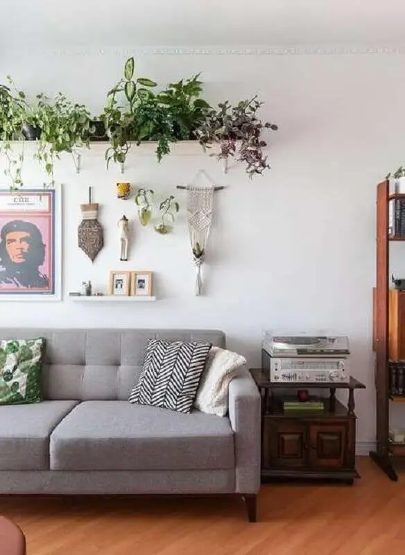 sala de estar decorada com sofá cinza e prateleira para plantas Foto Histórias de Casa