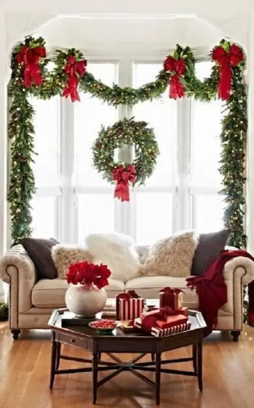 sala decorada com festão de Natal decorado com laços vermelhos Foto Witty Bash