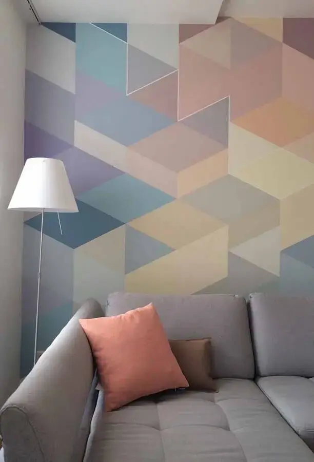 sala decorada com sofá cinza e desenho geométrico na parede colorida Foto Eduardo Cavalcanti Castro