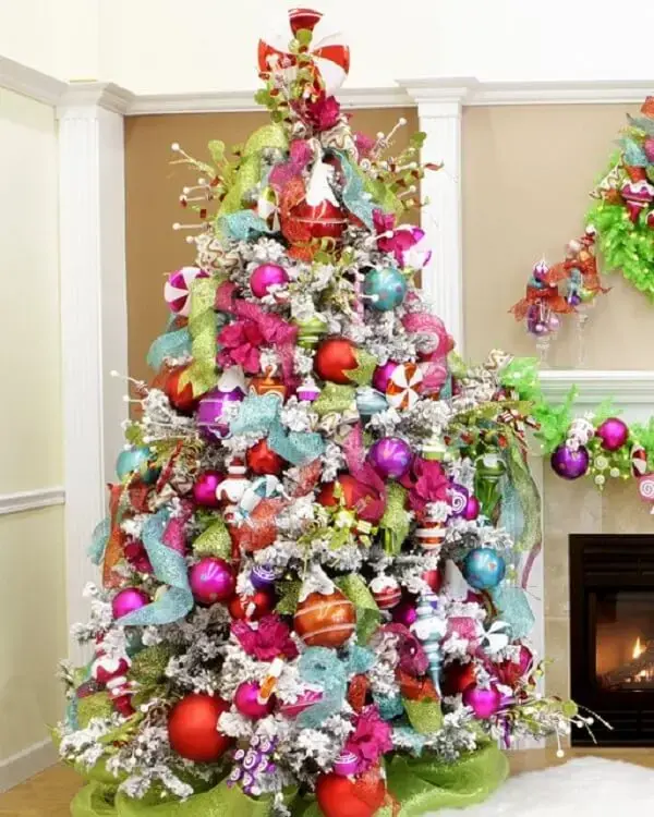 Árvore de natal alegre com decoração azul, rosa, laranja e verde