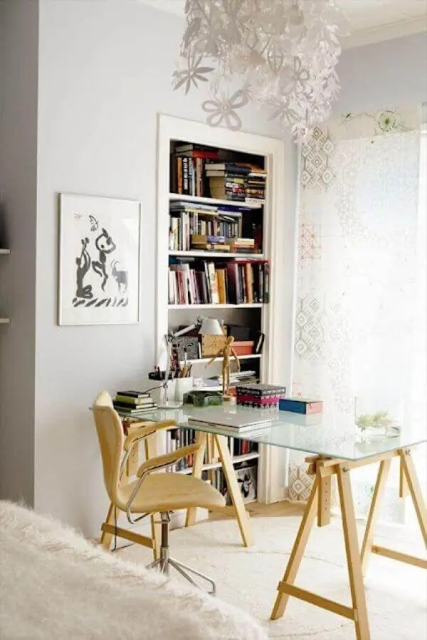 A mesa de vidro para escritório com cavalete de madeira traz um toque rústico para a decoração