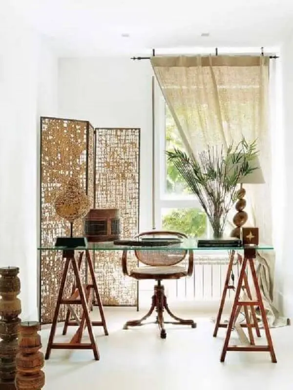 A mesa para escritório com tampo de vidro e base cavalete é a grande protagonista da decoração