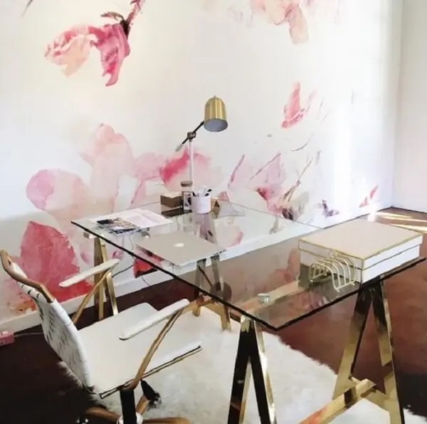 Ambiente delicado com papel de parede flora e mesa de vidro para escritório