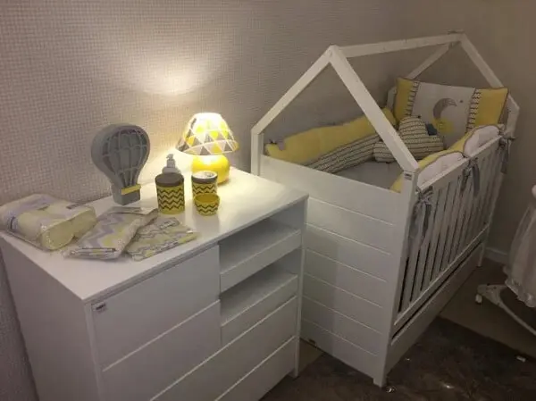 Branco e amarelo para decoração desse quarto de bebê com berço com gaveta