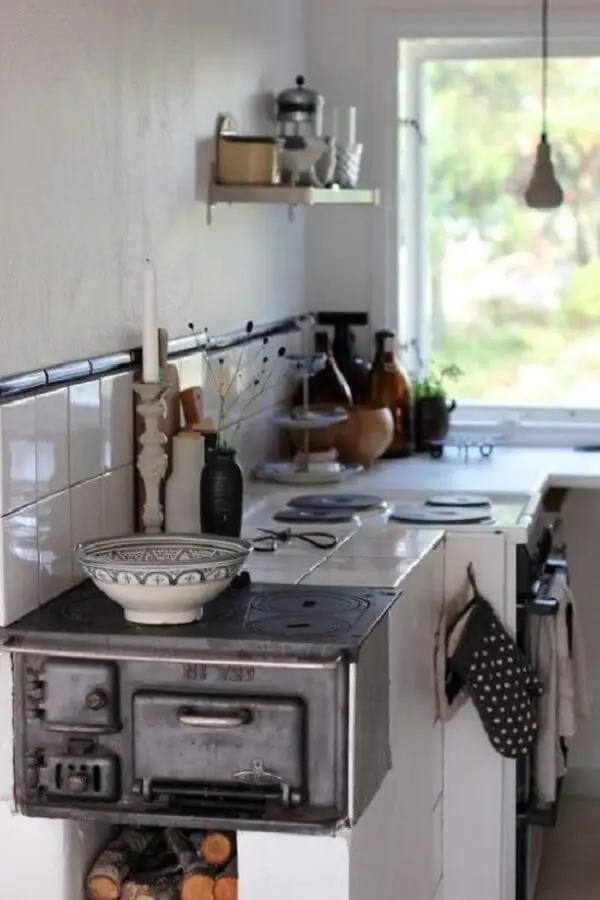 Cozinha com fogão a lenha simples e instalado na ponta da bancada