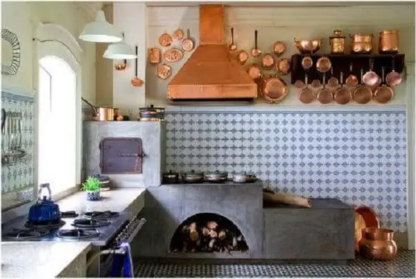 Cozinha planejada com fogão à lenha e com espaço para guardar madeira