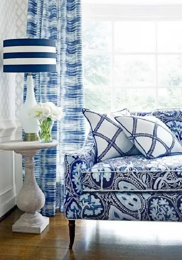 O azul predomina na decoração dessa sala com sofá estampado