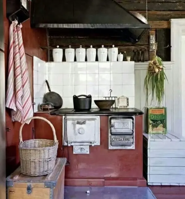 O azulejo branco se destaca na cozinha com fogão à lenha