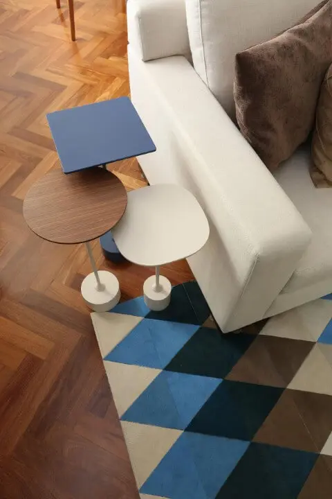 Sala de estar com mesa lateral alta e tapete geométrico