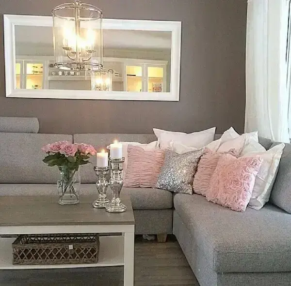 Sala decorada com sofá de canto linho cinza e almofadas em tons de rosa e branco