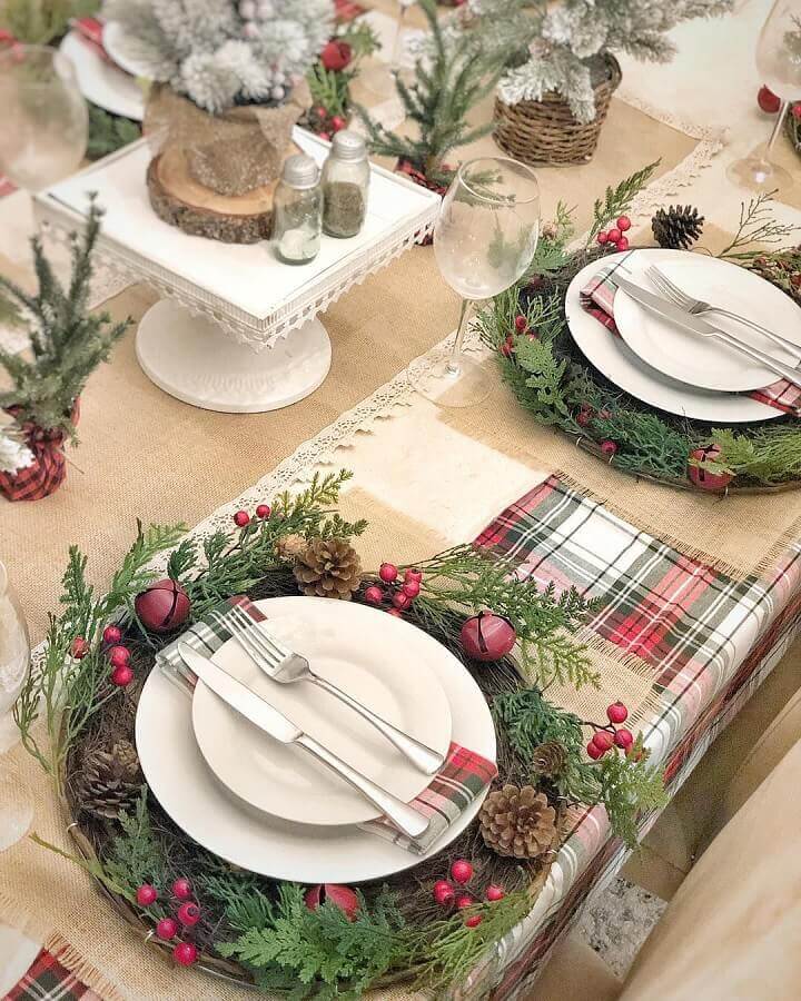 arranjos de Natal para mesa com pinhas e guirlanda ao redor dos pratos com guardanapos xadrez  Foto Rustic & Woven