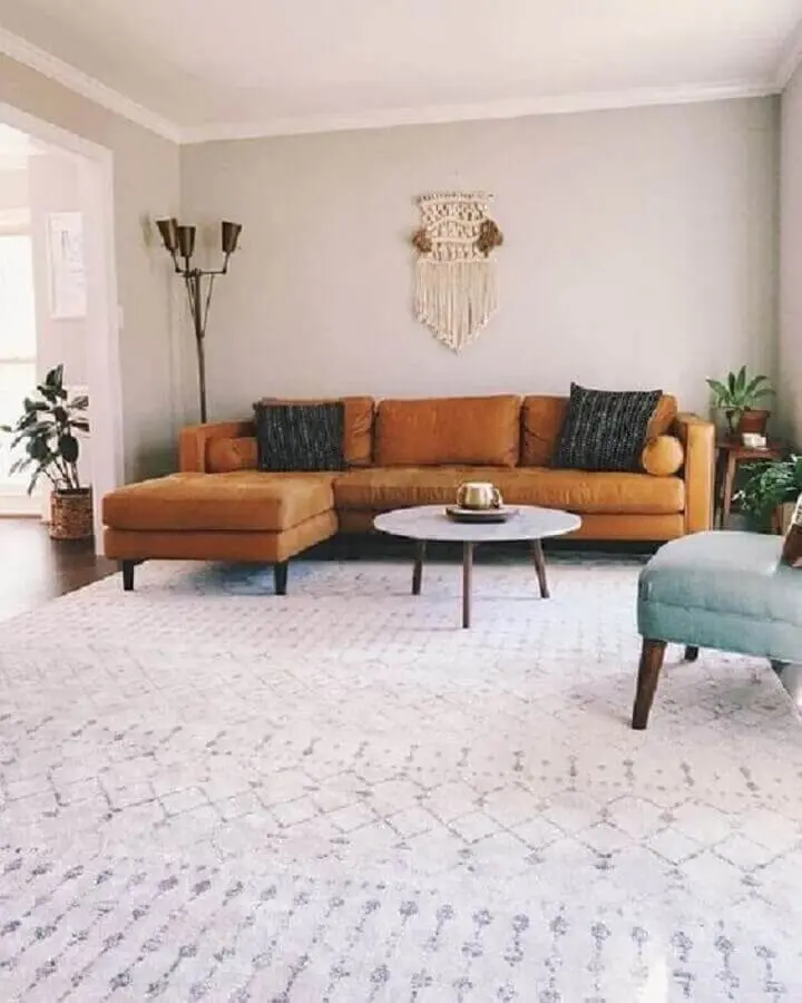 decoração clean para sala com mesa de centro redonda e sofá marrom com chaise Foto Pinterest