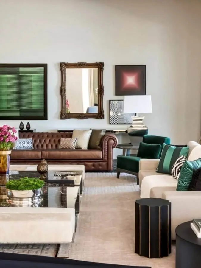 decoração de sala ampla com sofá marrom chesterfield e poltronas brancas e verde Foto Maurício Karam