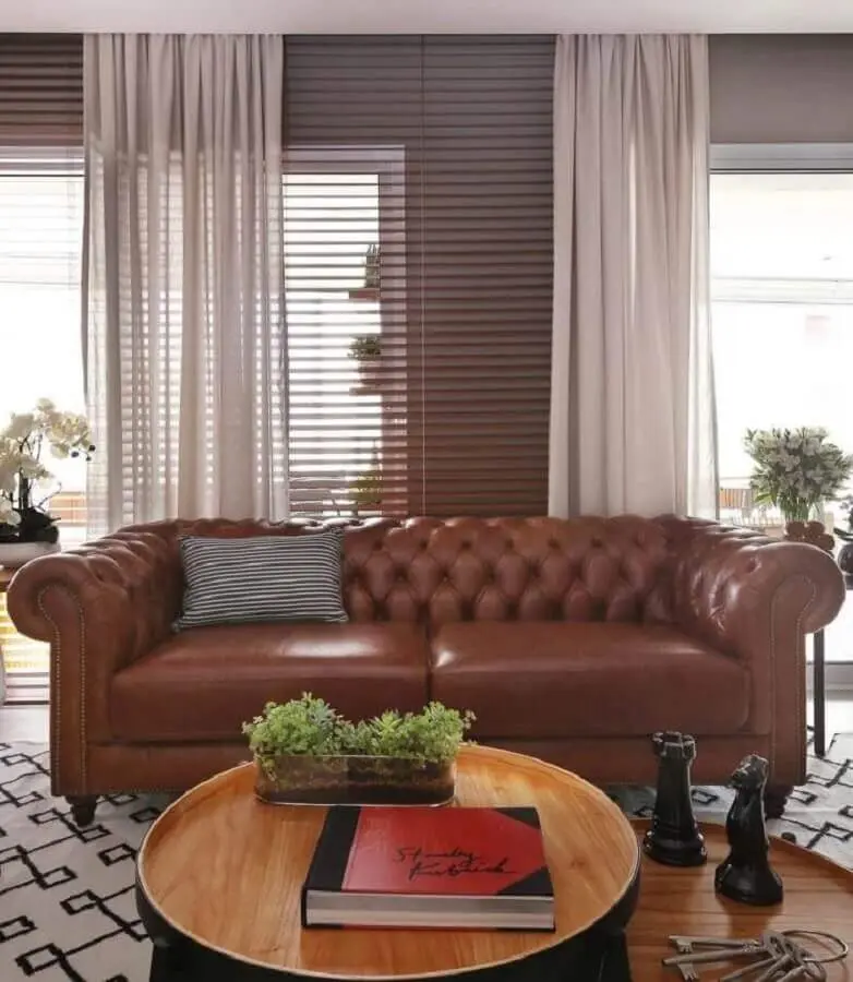 decoração de sala com sofá de couro marrom chesterfield e mesa de centro redonda Foto Estúdio AE Arquitetura