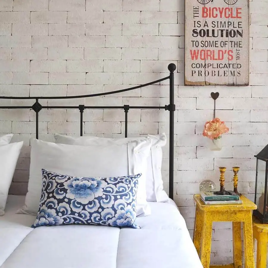 decoração simples para quarto com parede de tijolinho branca e cabeceira preta de ferro Foto Soul Casa