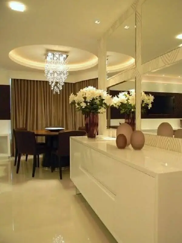 decoração sofisticada para sala de jantar com buffet branco suspenso e espelho de parede bisotado Foto Lolafá