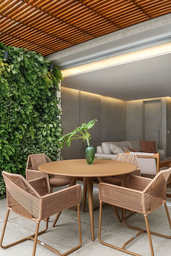 Mesa redonda para varanda gourmet rústica com jardim vertical na decoração