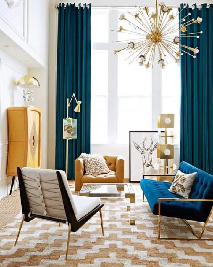 poltrona para sala colorida decorada com lustre pendente moderno e sofá azul Foto The Fashion Hall