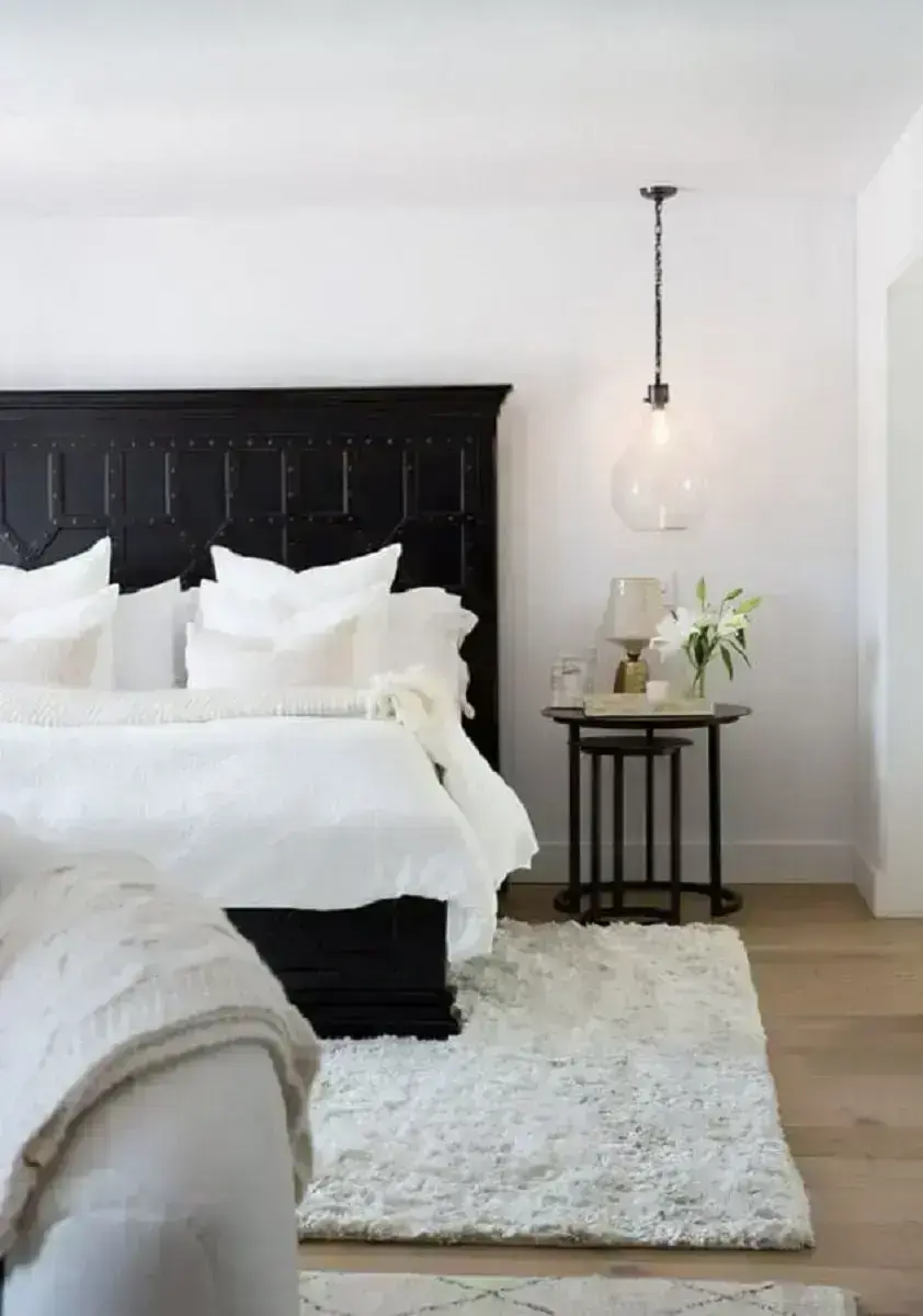 quarto de casal todo branco decorado com cabeceira preta e luminária pendente Foto MyDomaine