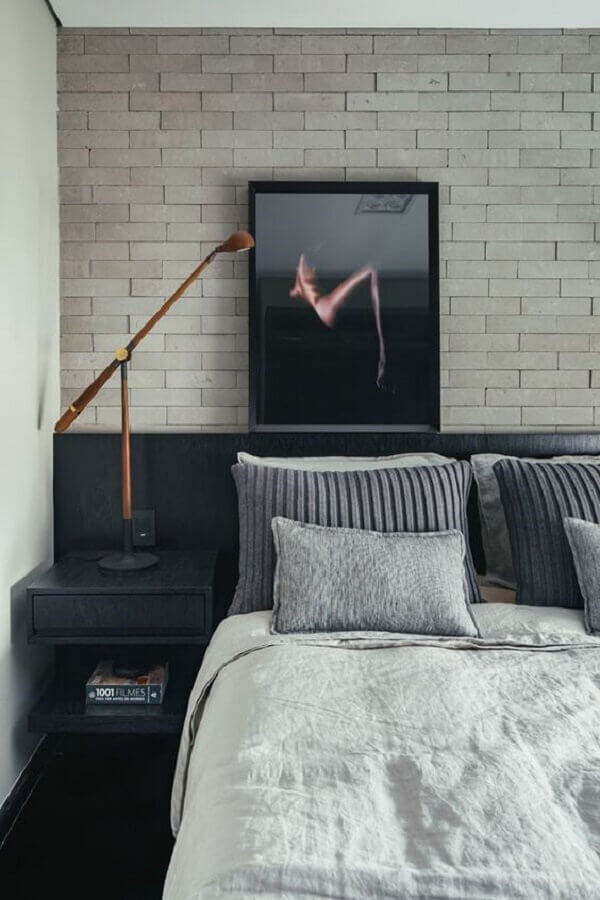 quarto moderno decorado com parede de cimento queimado e cabeceira preta de madeira com criado mudo Foto Homedit