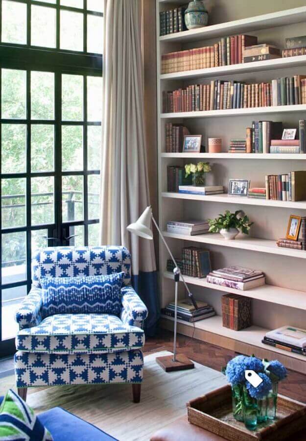 sala decorada com estante planejada e poltrona colorida azul e branca Foto Pinterest