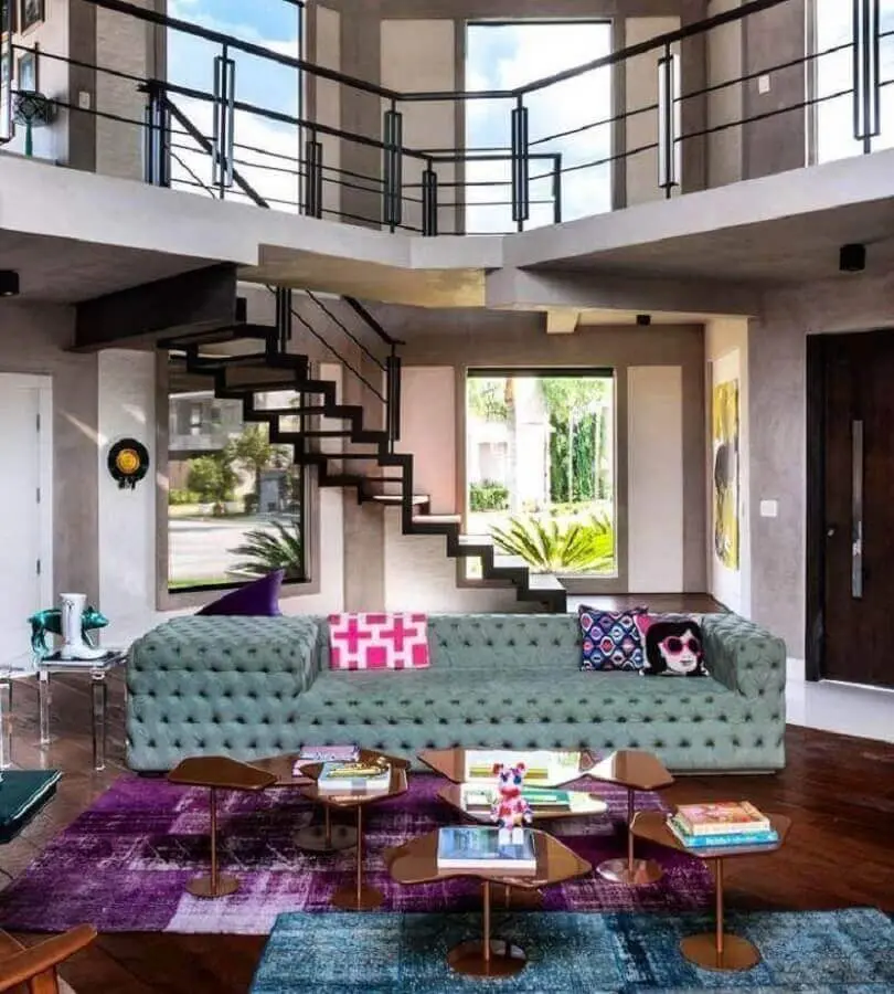 sala moderna decorada com tapete roxo e sofá grande capitonê Foto Ronaldo Rizzutti