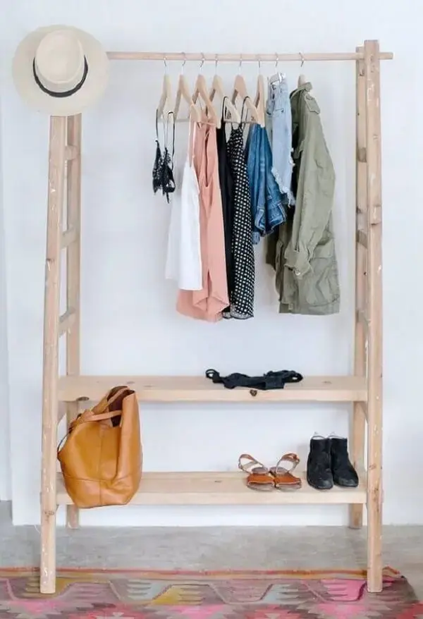 A arara cabideiro de madeira acomoda várias roupas, bolsas e sapatos