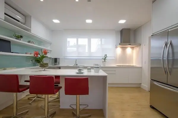 A bancada vermelha na cozinha clean quebra a neutralidade do espaço