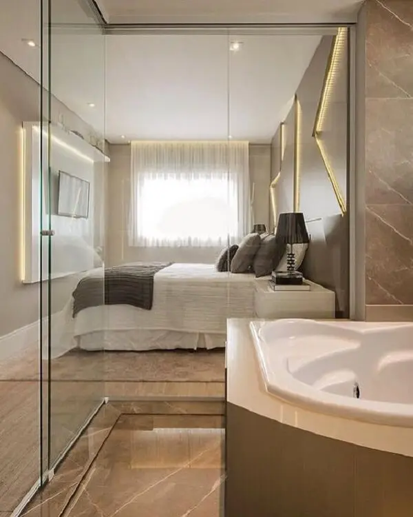 A banheira é a protagonista desse quarto com suíte de vidro