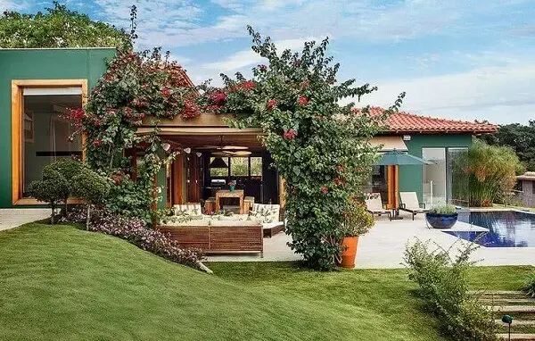 A pintura verde das casas de campo com varandas se harmonizam com a vegetação do entorno