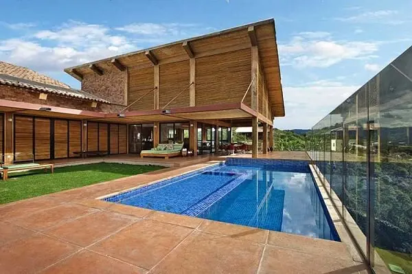 As piscinas também são muito bem vindas nos projetos de casas de campo com varanda e churrasqueira