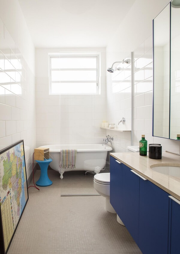 Banheiro com gabinete azul e chuveiro cromado