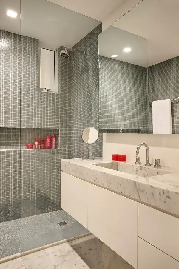 O chuveiro elétrico cromado passa quase despercebido na decoração desse banheiro