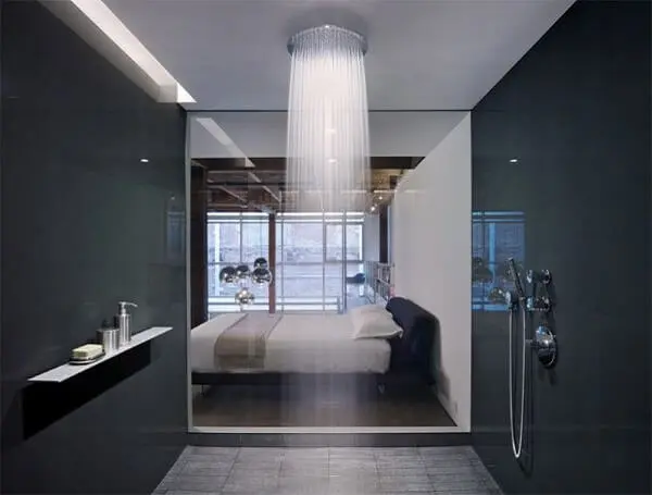 O chuveiro é a grande atração desse quarto com suíte de vidro