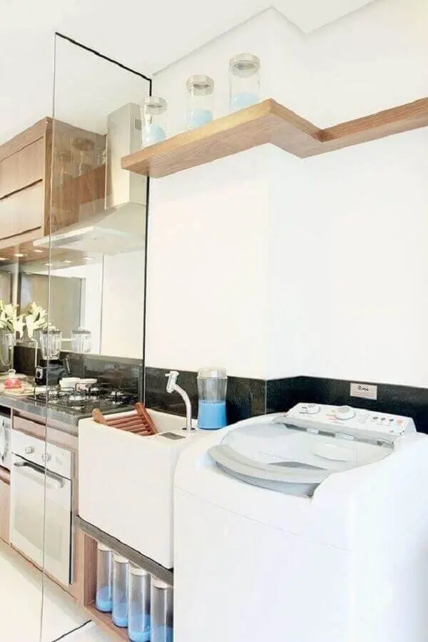 O painel de vidro serve de divisória entre a cozinha e a área de serviço simples