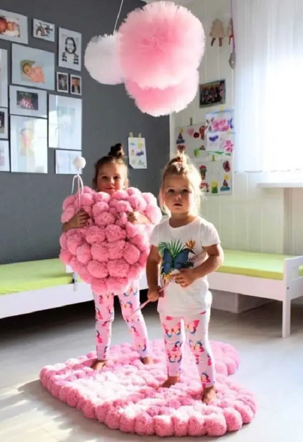 O tapete rosa para quarto infantil feito em pompons é macio e tem a capacidade de absorver o impacto de tombos e quedas