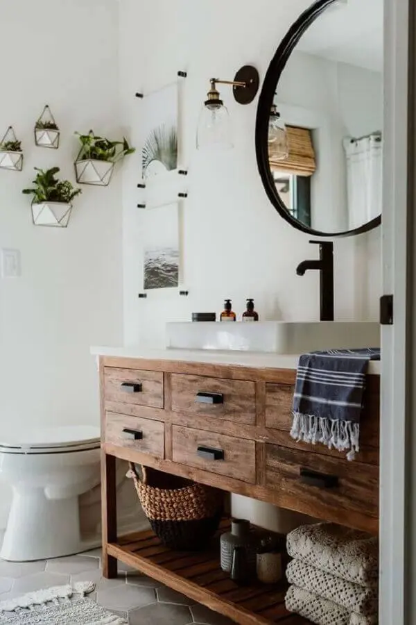 arandela para banheiro simples decorado com espelho redondo e gabinete rústico de madeira Foto Decoholic