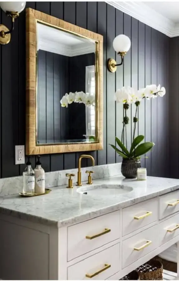 decoração clássica com arandela para banheiro preto com gabinete branco e detalhes em dourado