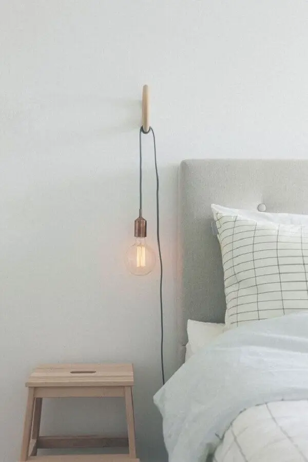 decoração de quarto minimalista com luminária de parede e cabeceira estofada Foto The Lifestyle Files