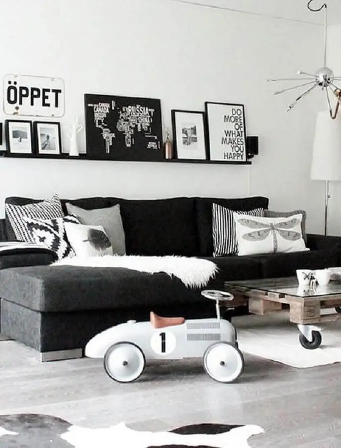 decoração de sala preto e branco com sofá sem braço e prateleira para quadros Foto Jeito de Casa