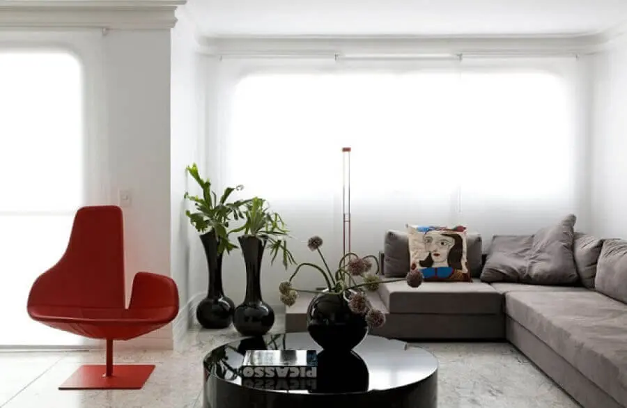 mesa de centro redonda preta para decoração de sala com poltrona vermelha moderna e vasos de chão Foto eh!DÉCOR