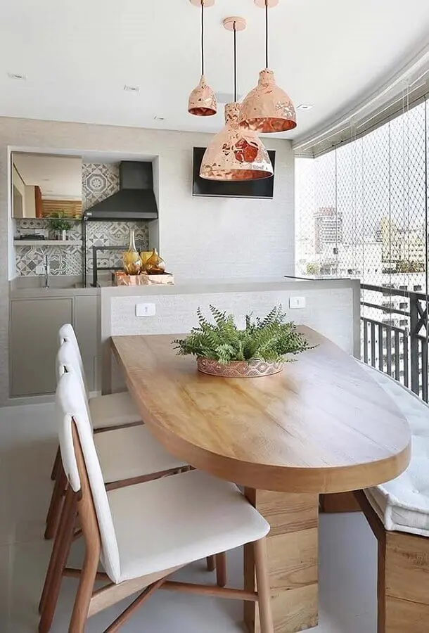 mesa de madeira planejada para decoração de varanda gourmet pequena com churrasqueira em apartamento Foto Jeito de Casa