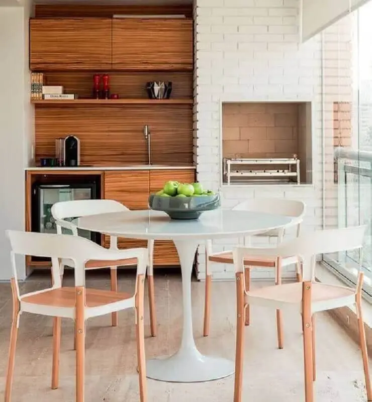 mesa redonda branca para decoração de varanda gourmet com churrasqueira em apartamento Foto Jeito de Casa