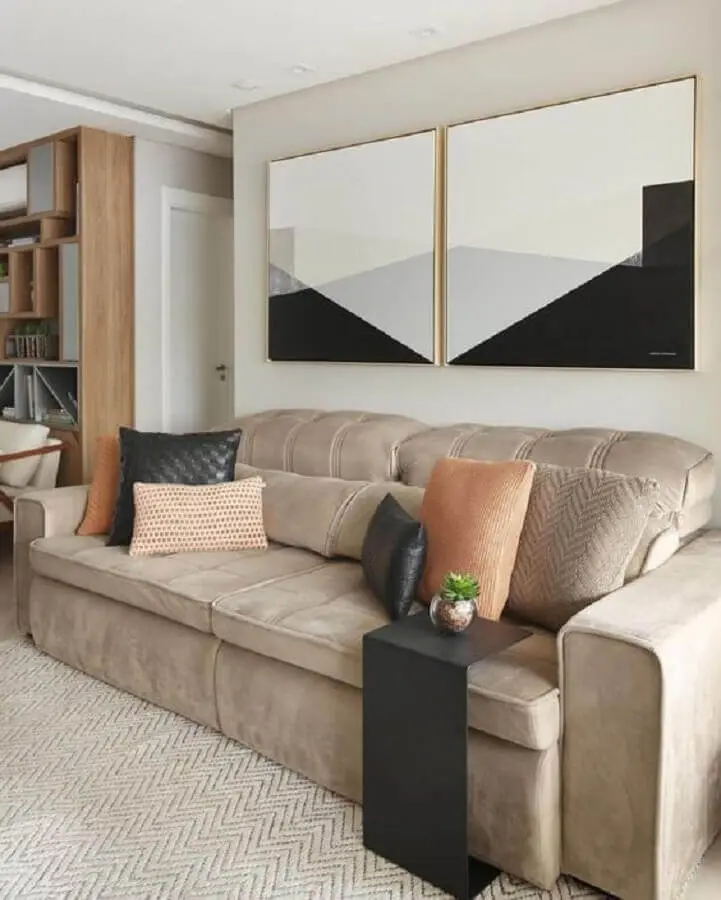 sala com sofá bege decorado com almofadas decorativas e quadros abstratos Foto Jeito de Casa