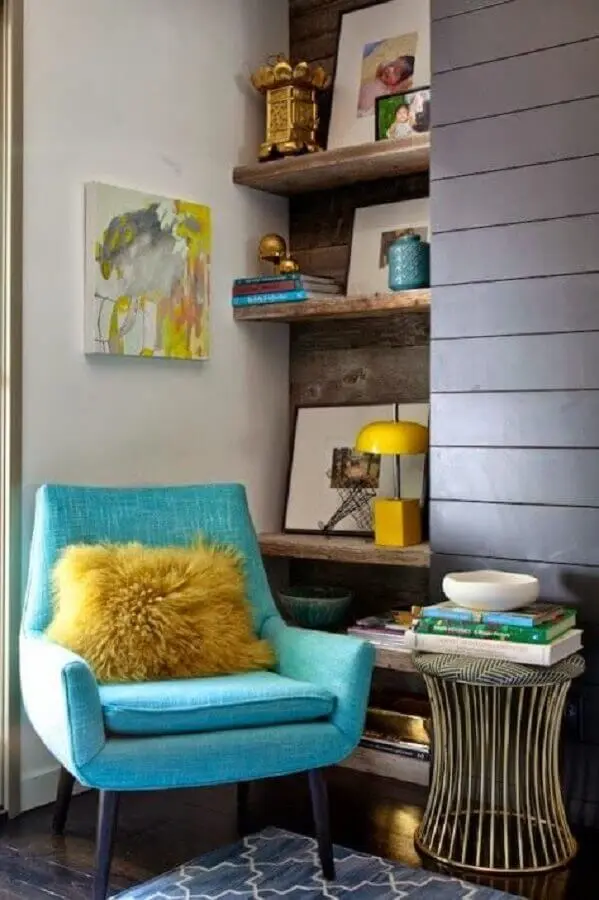 sala decorada com prateleira de madeira rústica e poltrona azul turquesa Foto Arquitrecos