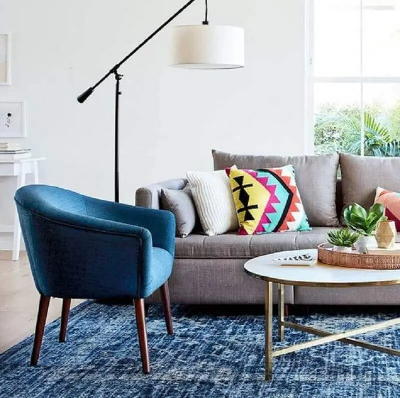 sofá cinza para decoração de sala com poltrona azul petróleo e luminária de chão Foto Simplichique