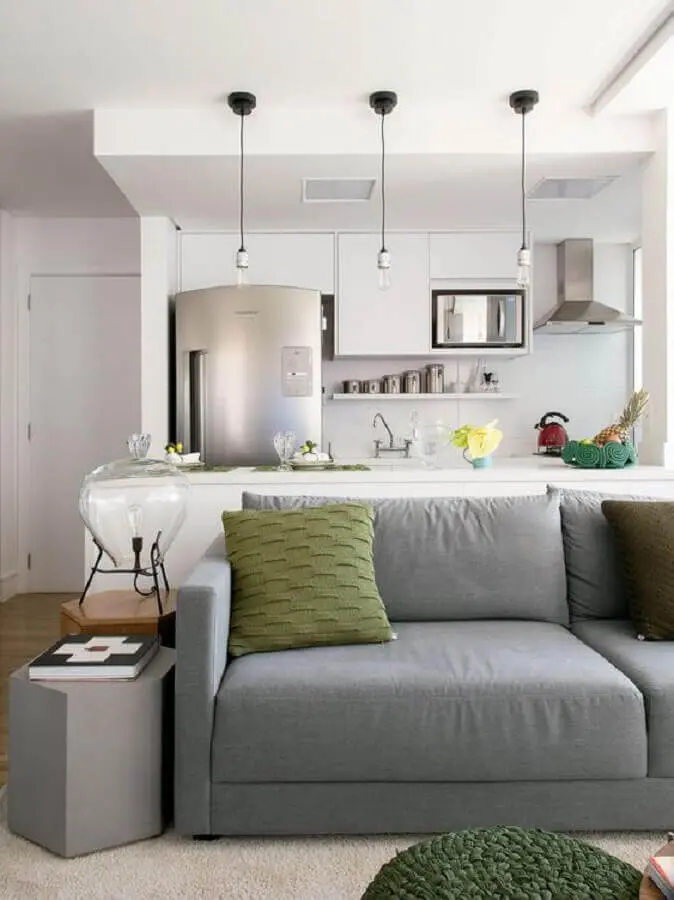 sofá cinza para sala e cozinha integrada com armários brancos Foto Histórias de Casa