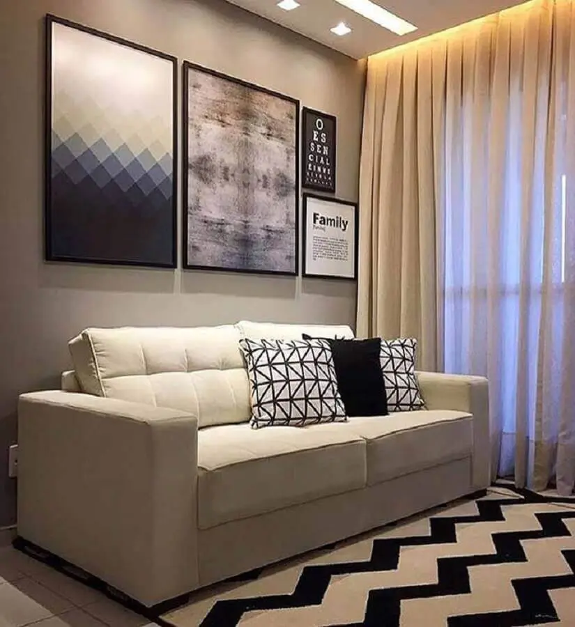 sofá pequeno para decoração de sala com quadros grandes e tapete preto e branco Foto Jeito de Casa